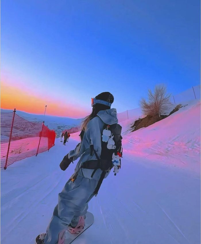 Snowboarder on a pink sunset ski run
