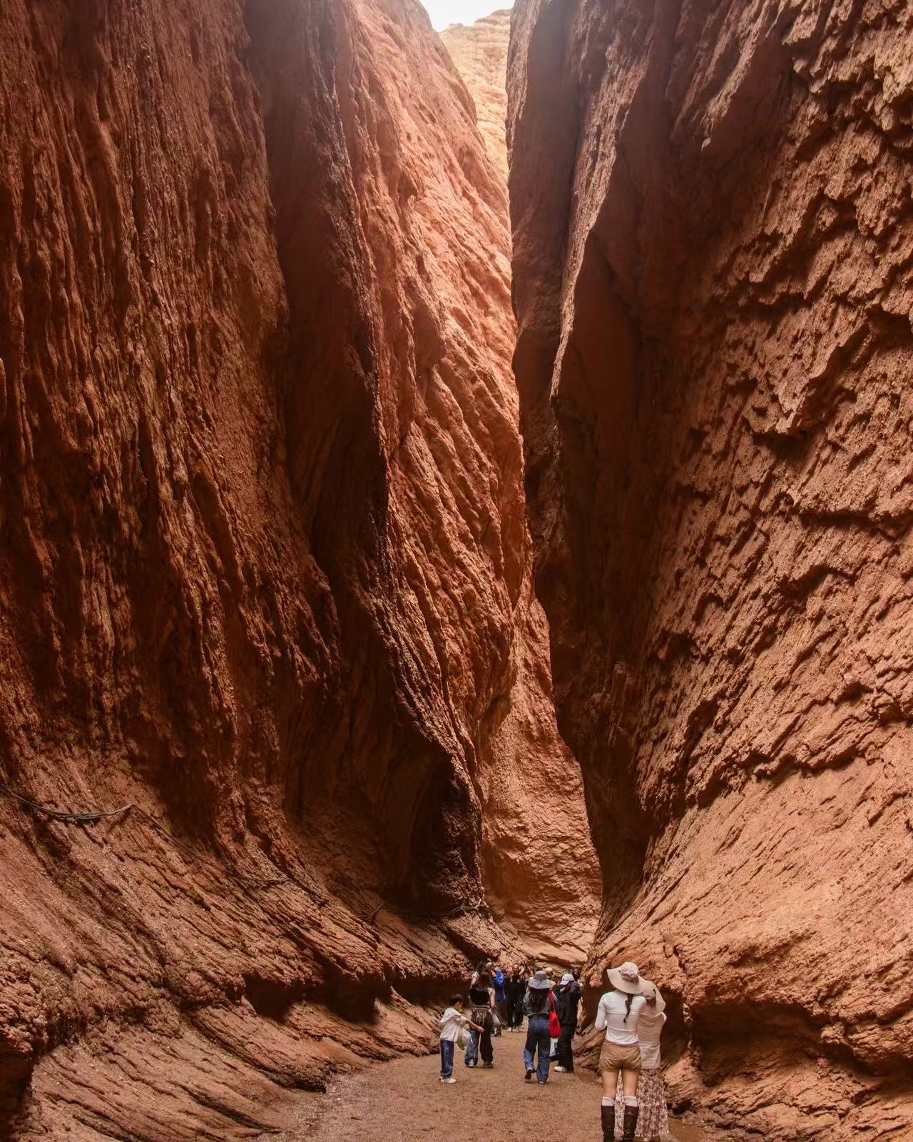 Travellers walking in a red canyon near Kashgar