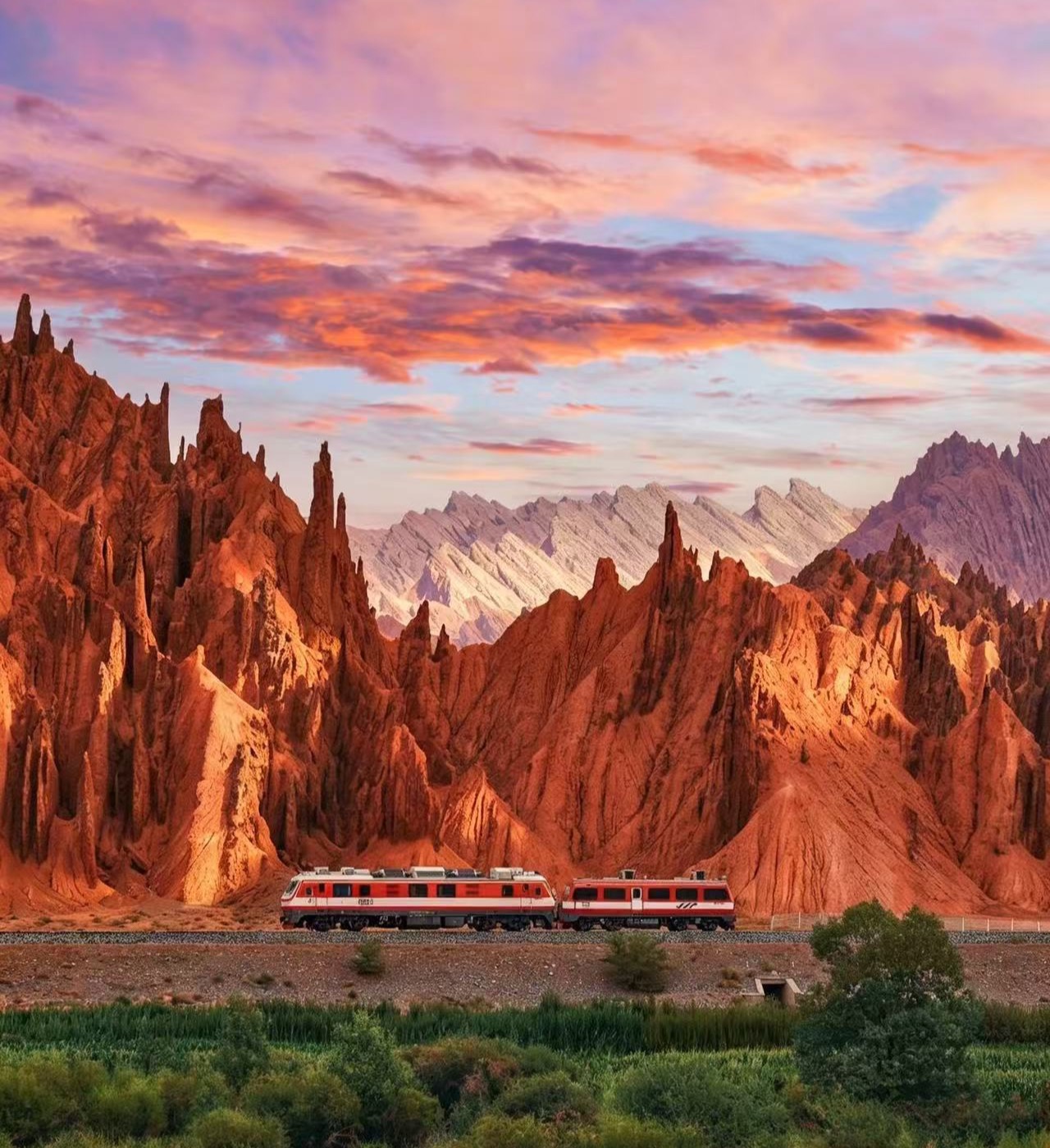 Train crossing a red canyon landscape at sunset